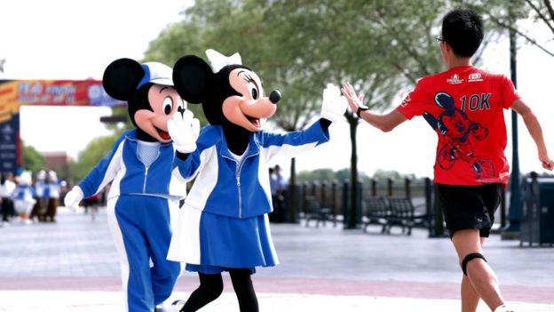 Mickey y Minnie Mouse saludando a un niño.