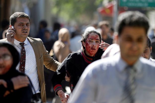 Injured Afghans run from the site of a blast in Kabul, Afghanistan 31 May 2017.