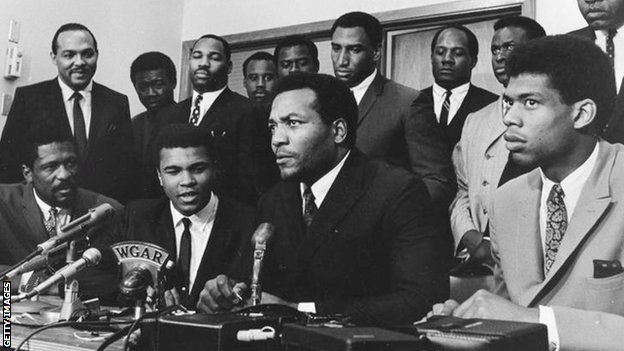 Muhammad Ali and Jim Brown, with a group of prominent black athletes supporting Ali's decision to reject being drafted for the Vietnam War