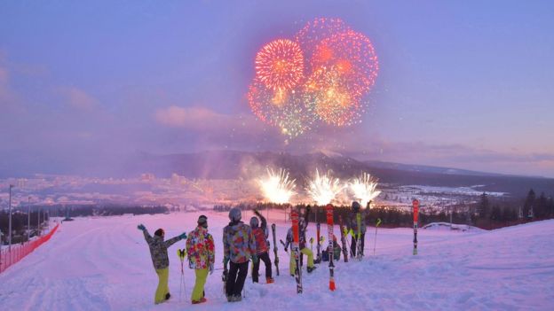 esquiadores observan fuegos artificiales por inauguración del pueblo de Samjiyon