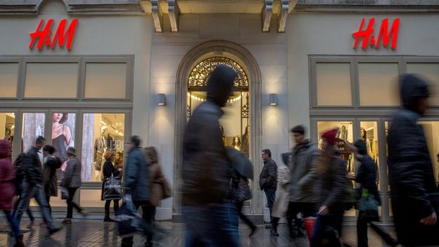 Gente caminando frente a una tienda H&M.