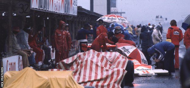 Jochen Mass and James Hunt (both McLaren M23 Fords) in the pits waiting for the rain to stop.