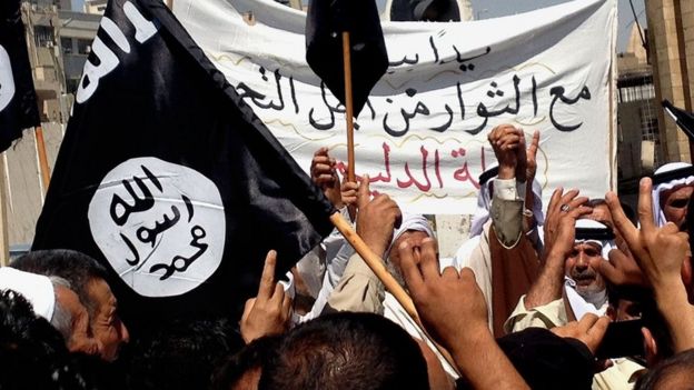 Islamic State supporters attend a rally outside the Nineveh provincial government headquarters in Mosul (16 June 2014)