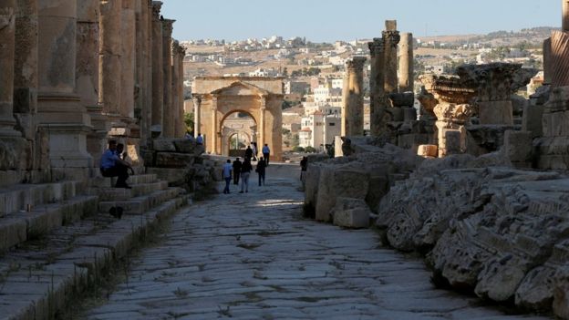 People walk along the ruins of the ancient Roman city of Jerash