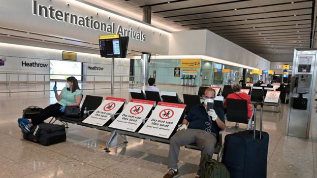 Passengers sit socially distanced in the arrivals hall in Heathrow Airport