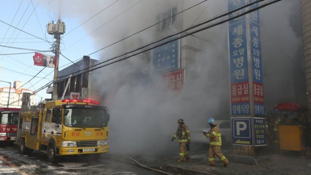 Firefighters try to put out a fire at a hospital in Miryang, southeastern South Korea, 26 January 2018.