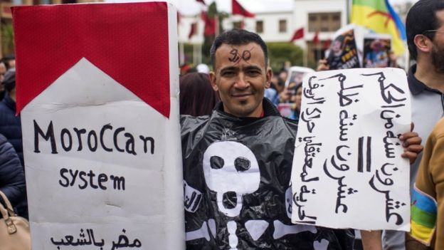 A Moroccan protester holds a banner reading in Arabic "20-year sentence = 20-years injustice"