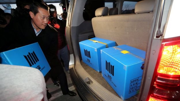 A prosecution investigation officer moves boxes carrying evidence seized at a branch office of National Pension Service (NPS) in Jeonju, South Korea, November 23, 2016