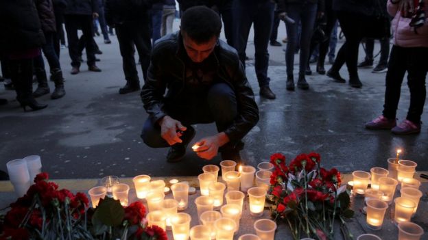 Un hombre enciende una vela en memoria de las víctimas de la explosión en el metro
