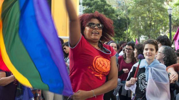 mulher com bandeira do movimento LGBT
