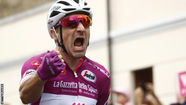 Elia Viviani celebrates victory after crossing the line on stage 13