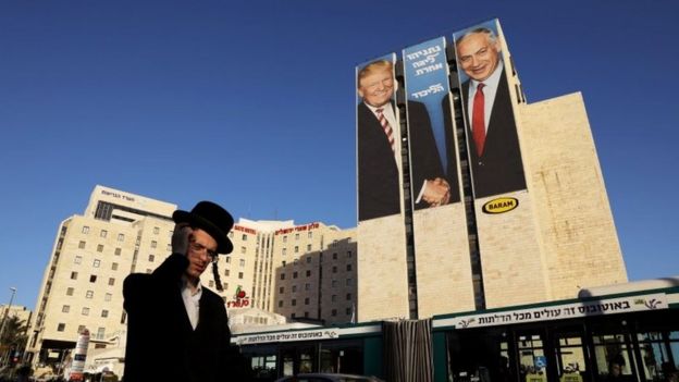 A man walks past a Likud election campaign billboard, depicting U.S. President Donald Trump shaking hands with Israeli Prime Minister Benjamin Netanyahu, in Jerusalem on 4 February 2019.