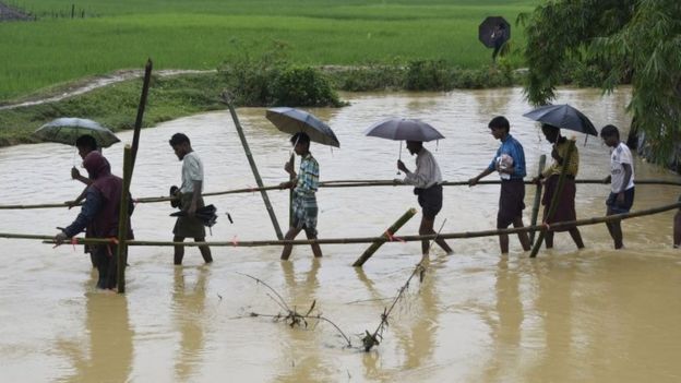 Rohingya Muslim refugees cross floodwater in Thyangkhali refugee camp near the Bangladesh town of Ukhia on 17 September 2017.