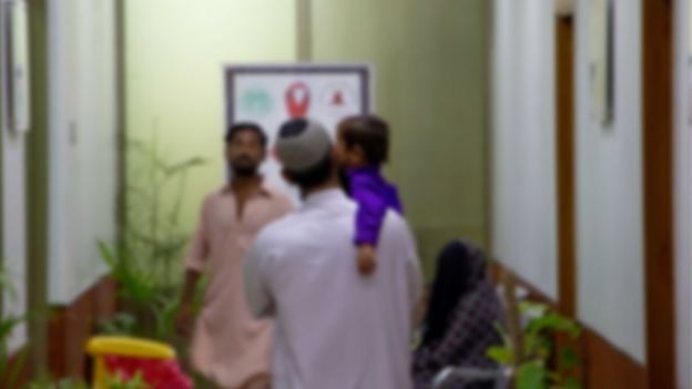 Un hombre con un niño en una clínica de Pakistán.