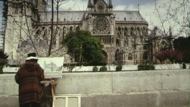 A Paris street artist paints the Notre-Dame