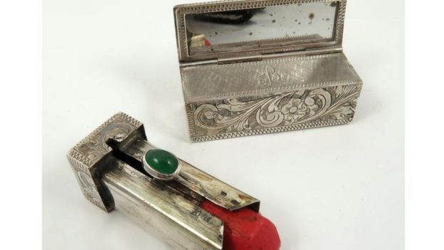 A silver lipstick case and red lipstick