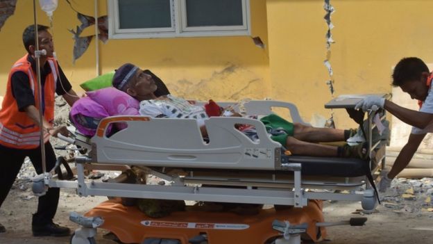 Staff take patients outside as a safety measure at a hospital in Mataram