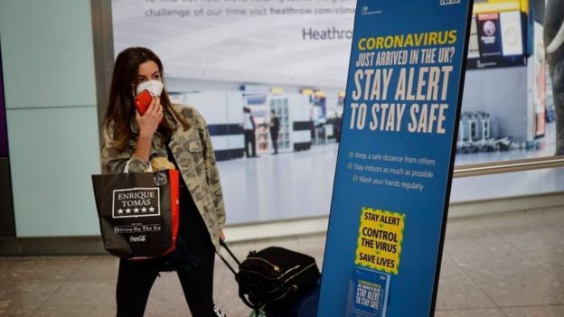 A passenger wears a mask in London's Heathrow Airport