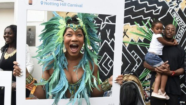 A dancer poses smiling during the Notting Hill Carnival
