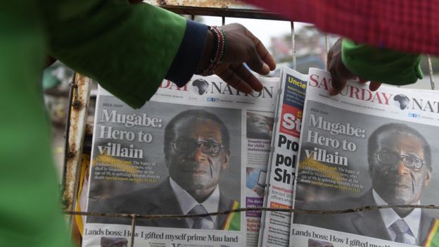 A man buys a daily newspaper at a stand on the streets of Nairobi following Robert Mugabe's death
