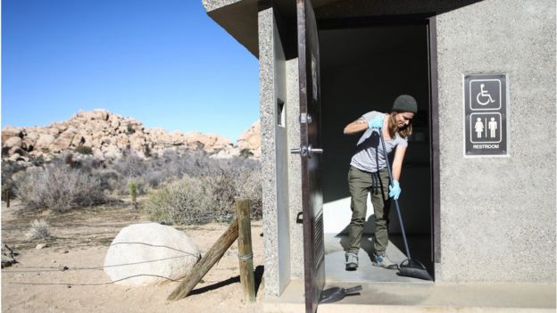 Una voluntaria limpia un baño en el parque nacional Joshua Tree de California