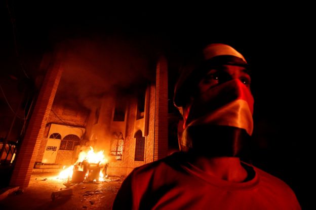 Iraqi protesters are seen near the burnt Iranian Consulate in Basra, 7 September 2018