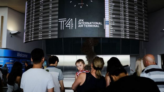 People walk through international arrivals at terminal four at John F Kennedy (JFK) airport