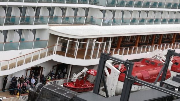 Passengers disembark from the 151,000-tonne World Dream cruise liner docked at the Kai Tak Cruise Terminal in Hong Kong, China, 9 February 2020