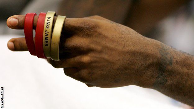 LeBron James plays with his 'King James' wrist bands as he sits on the bench against the Portland Trail Blazers on 17 January, 2006