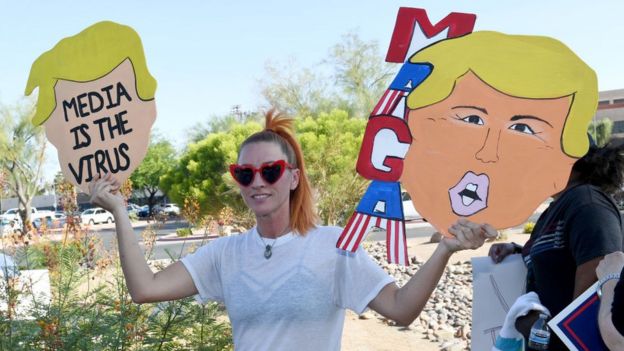 Partidaria de Trump con un cartel crítico con los medios de comunicación.