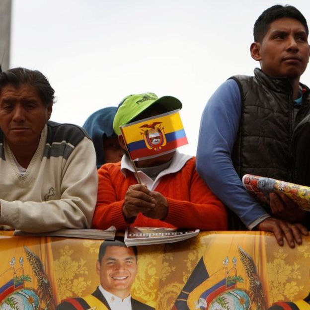 Hombres con bandera de Ecuador e imágenes de Correa.
