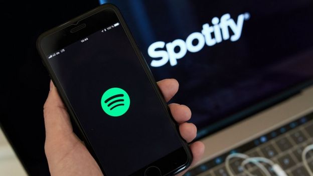 Una persona sostiene un móvil con la app de Spotify