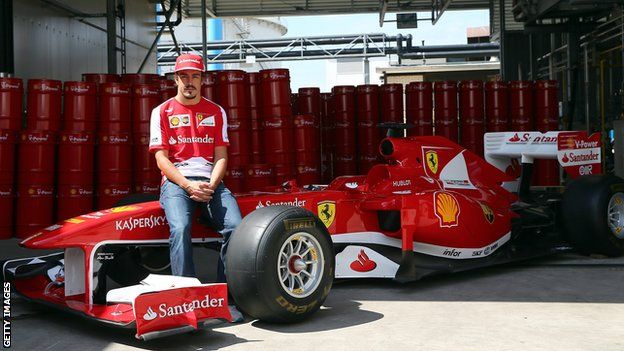 Fernando Alonso poses with the Ferrari car