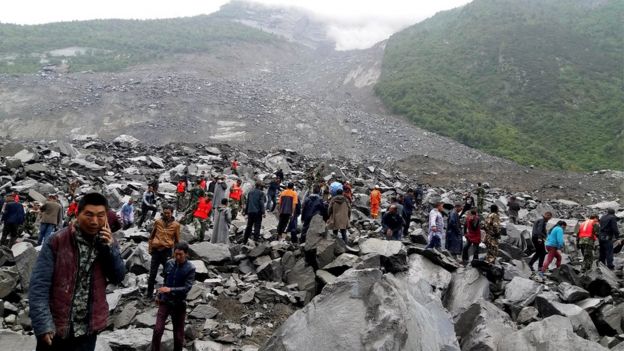 Los miembros de los equipos de rescate buscan entre las rocas a los desaparecidos por el deslave en Sichuan, China.