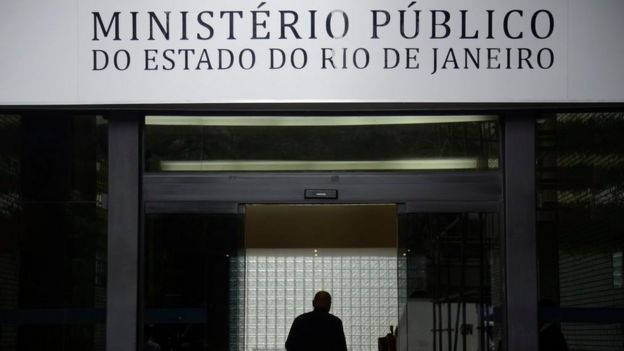 Fachada diz Ministério Público do Rio de Janeiro, com sombra de homem ao fundo