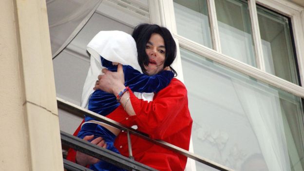 Michael Jackson con su hijo en un balcón.
