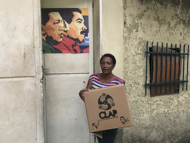 Una mujer con una caja CLAP