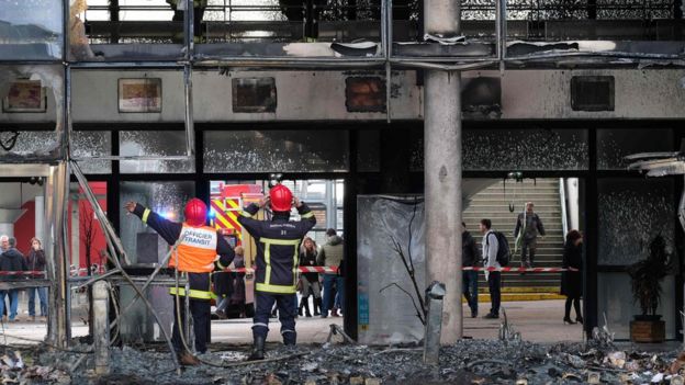 Bombeiros trabalham na entrada de uma escola em Blagnac, no Sul da França, destruída por fogo quando os estudantes protestavam