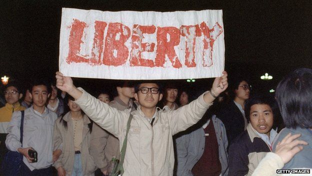 Student displays a banner with one of the slogans chanted by the crowd of some 200,000 pouring into Tiananmen Square 22 April 1989 in Beijing in an attempt to participate in the funeral ceremony of former Chinese Communist Party leader and liberal reformer Hu Yaobang during an unauthorized demonstration to mourn his death