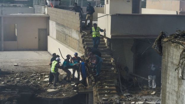 Rescuers evacuate an injured resident from the site, where a number of houses were destroyed