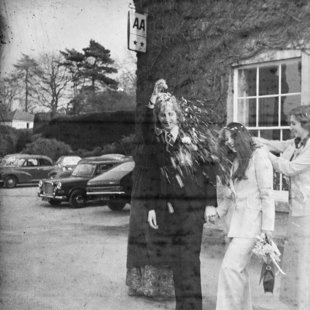 Black and white photo of mystery newly-weds outside two star hotel