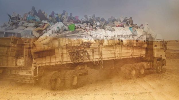 Migrantes en un camión en el desierto.