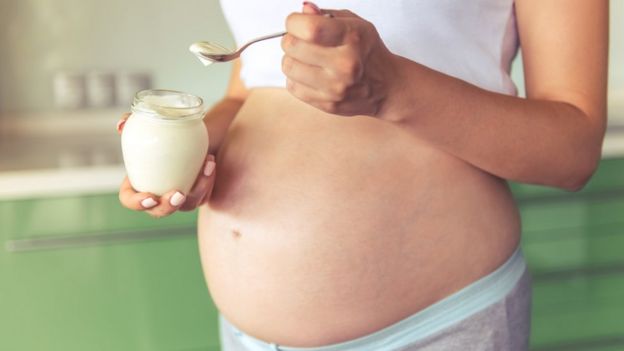 mujer embarazada comiendo lácteo
