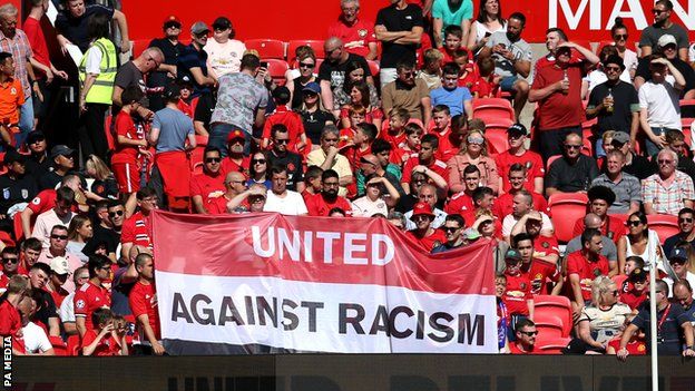 Manchester United fans with an anti-racism banner