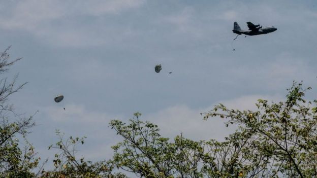 Avión y paracaidistas saltando