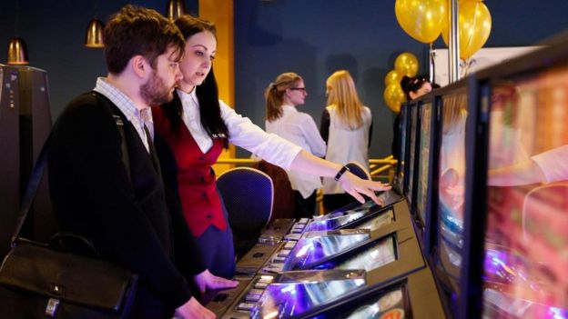 أشخاص يقفون أمام ماكينة للقمار