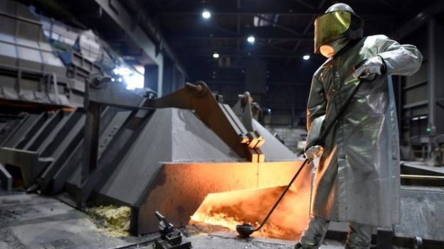 A worker at German steel manufacturer Salzgitter AG stands in front of a furnace at a plant in Salzgitter, Germany, March 1, 2018