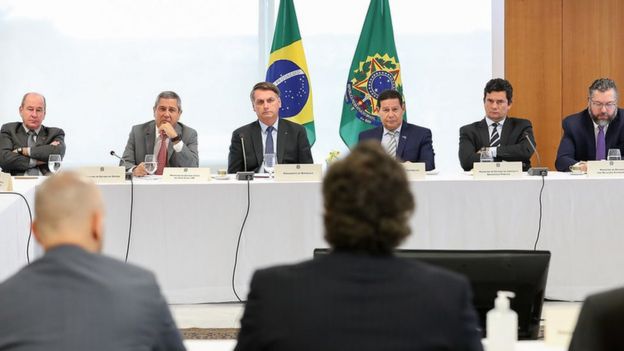 Bolsonaro sentado ao lado de vice-presidente e ministros
