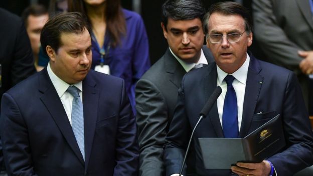 Bolsonaro faz o juramento de cumprimento à Constituição, ao lado de Rodrigo Maia