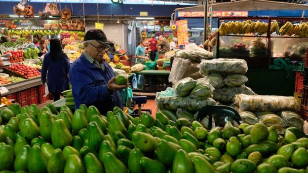 mercado com abacates em primeiro plano